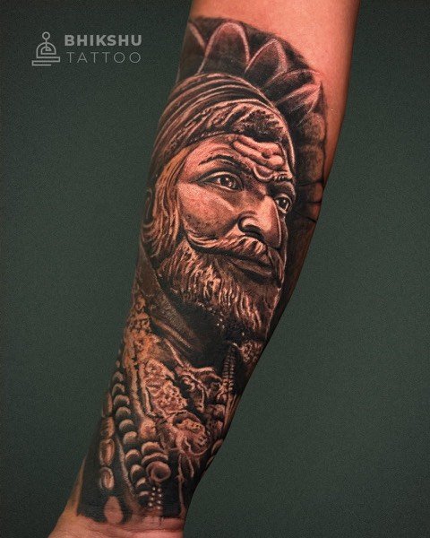 Realistic portrait tattoo of Chhatrapati Shivaji Maharaj on the forearm