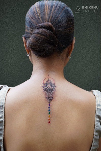 Fine line lotus tattoo down the spine with coloured chakra dots